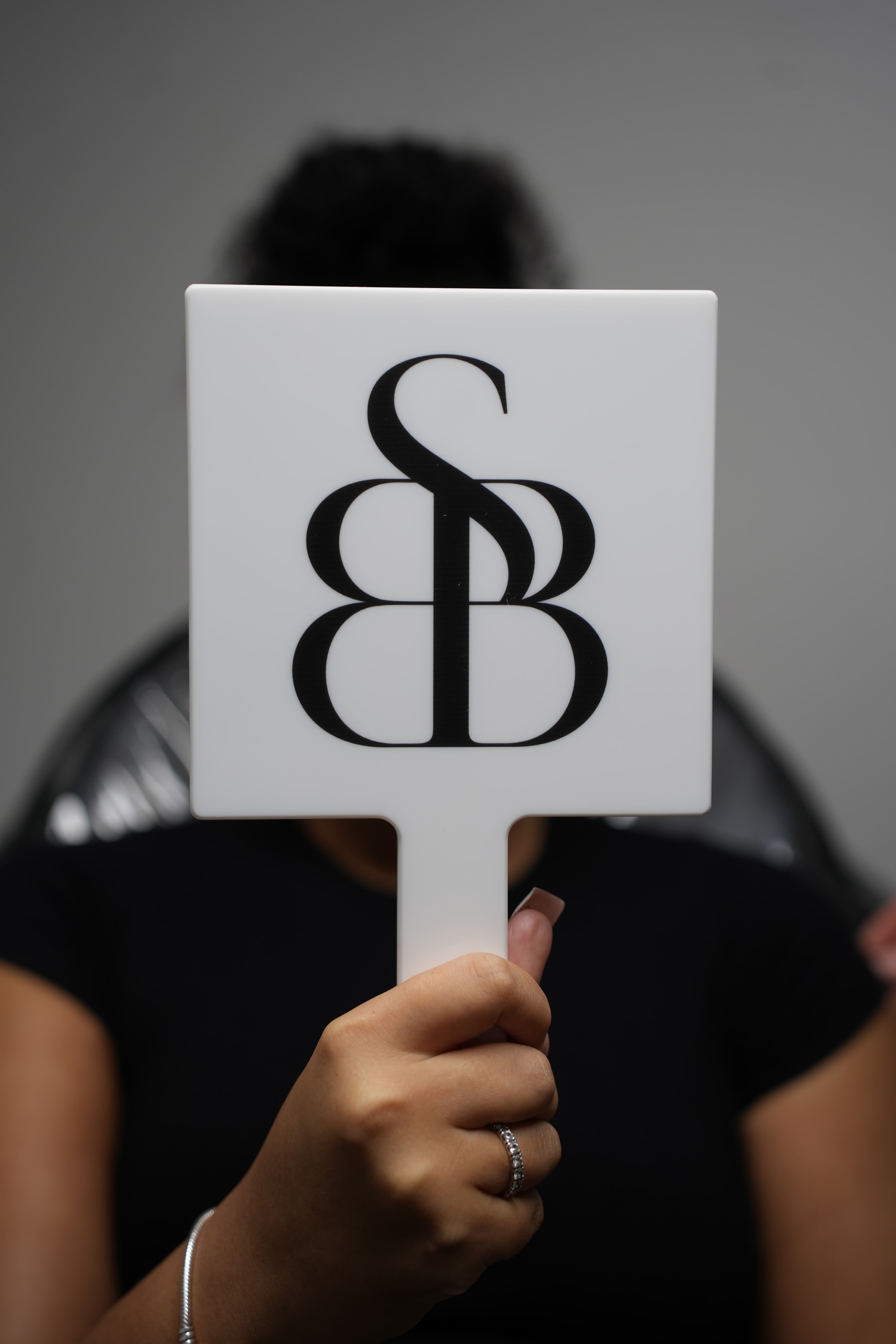 SII Beauty Boutique branded paddle held in studio